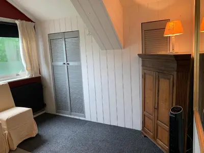 a room with a bed and a closet and a lamp at Holiday home at the water, fire place, boat and SUP rent, near Amsterdam in Aalsmeer