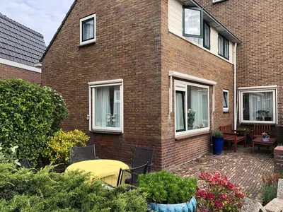 a brick house with a yellow table in front of it at Strandhuis Everts in Egmond aan Zee
