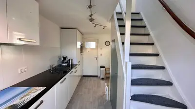 a staircase in a home with white walls at Strandhuis Everts in Egmond aan Zee