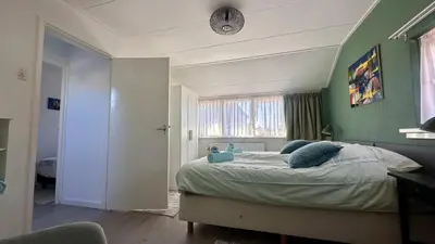 a bedroom with a bed with a green wall at Strandhuis Everts in Egmond aan Zee