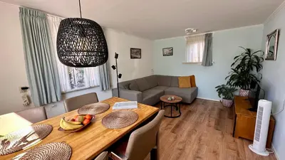 a living room with a dining table and a living room with a couch at Strandhuis Everts in Egmond aan Zee
