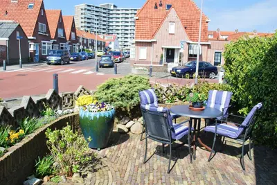 a patio with a table and chairs and a street at Strandhuis Everts in Egmond aan Zee