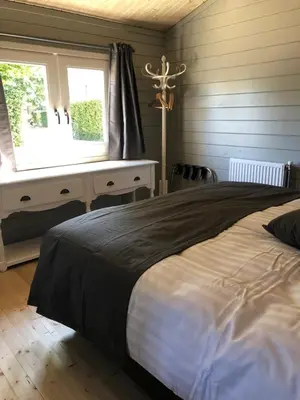 a bedroom with a bed and a desk and a window at Bed & Breakfast Zevenhuizen in Zevenhuizen