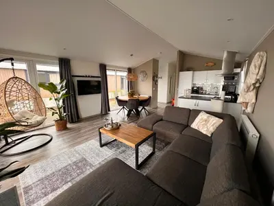 a living room with a couch and a table at Exclusieve vakantievilla ***** Markermeer in Bovenkarspel