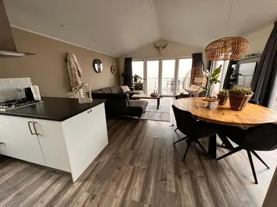 a kitchen and living room with a table and a couch at Exclusieve vakantievilla ***** Markermeer in Bovenkarspel