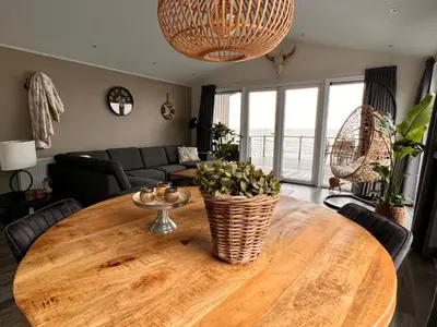 a living room with a wooden table and a couch at Exclusieve vakantievilla ***** Markermeer in Bovenkarspel