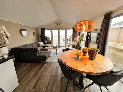 a living room with a wooden table and chairs at Exclusieve vakantievilla ***** Markermeer in Bovenkarspel