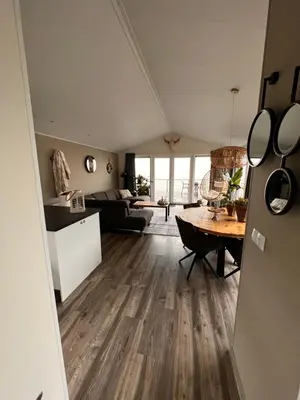 a living room with a couch and a table at Exclusieve vakantievilla ***** Markermeer in Bovenkarspel