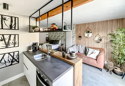 a kitchen and living room with a pink couch at Oasis Studio- Free Parking in Zandvoort