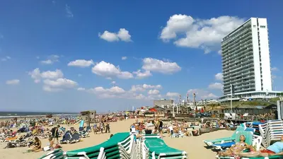 a crowd of people on a beach with a building at Oasis Studio- Free Parking in Zandvoort