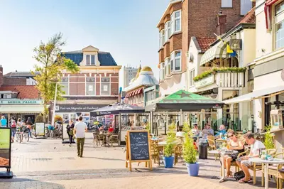 a group of people sitting at tables on a city street at Oasis Studio- Free Parking in Zandvoort