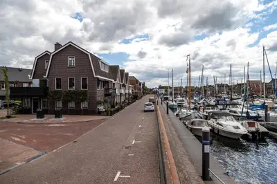 a marina with boats parked next to a building at B&B de Nieuwe Haven in Bunschoten