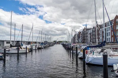 a group of boats docked in a harbor with buildings at B&B de Nieuwe Haven in Bunschoten