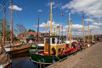 a group of boats are docked at a dock at B&B de Nieuwe Haven in Bunschoten