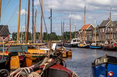 a group of boats docked in a harbor with houses at B&B de Nieuwe Haven in Bunschoten