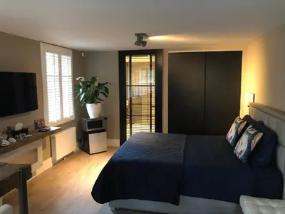 a bedroom with a bed and a desk and a television at B&B de Nieuwe Haven in Bunschoten