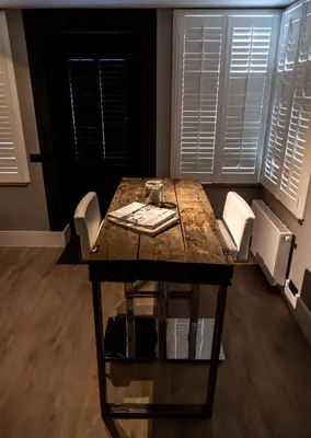 a dining room table with white chairs and a wooden floor at B&B de Nieuwe Haven in Bunschoten