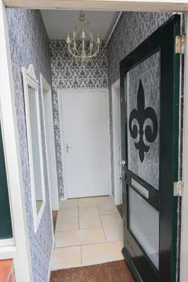 a hallway with a white door and a chandelier at Fleurdelis in Lisse