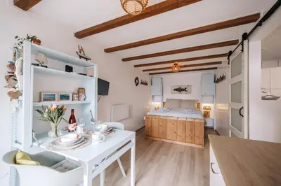 a kitchen and living room with a table and a bed at De Jutter - Zandvoort Free Parking in Zandvoort