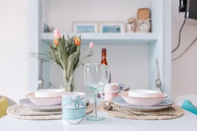 a table with plates and cups and a wine glass at De Jutter - Zandvoort Free Parking in Zandvoort