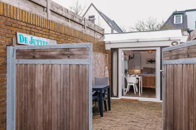 a patio with a wooden fence and a table at De Jutter - Zandvoort Free Parking in Zandvoort