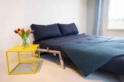 a bedroom with a bed and a vase of flowers on a table at Tulpenhoek in Akersloot