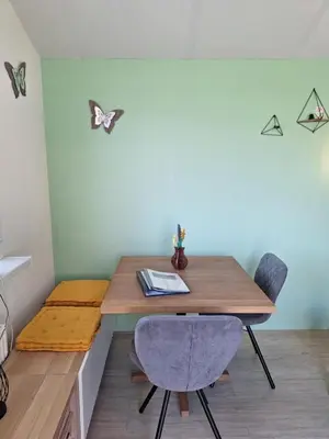 a dining room with a wooden table and two chairs at Rekerlanden 267 in Warmenhuizen
