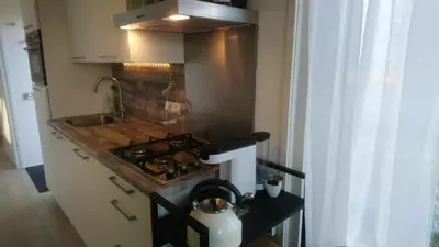 a kitchen with a stove top oven next to a sink at Rekerlanden 267 in Warmenhuizen