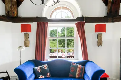 a blue couch in a living room with a window at Mondriaanmolen, a real Windmill close to Amsterdam in Abcoude