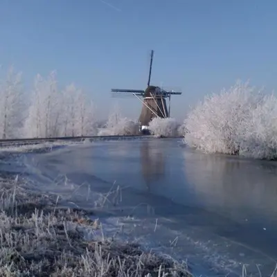 a windmill in the middle of a field with snow at Mondriaanmolen, a real Windmill close to Amsterdam in Abcoude