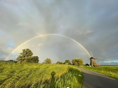 a rainbow over a road and a windmill at Mondriaanmolen, a real Windmill close to Amsterdam in Abcoude