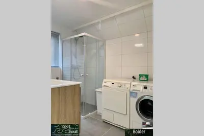 a kitchen with a washing machine and a washer at Wellness Bungalow Bolder 5p Amsterdam and the beach in Opmeer
