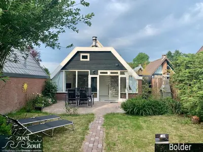 a small house with a picnic table in the yard at Wellness Bungalow Bolder 5p Amsterdam and the beach in Opmeer