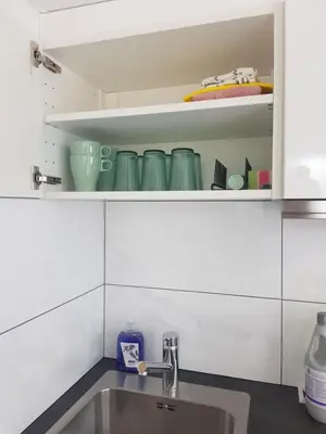 a kitchen with a sink and some green dishes at Mara's Place in Zandvoort