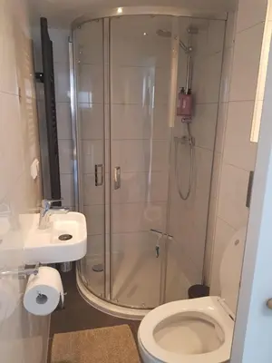 a bathroom with a shower and a toilet and a sink at Mara's Place in Zandvoort