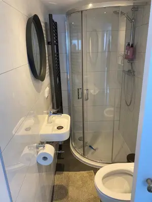 a bathroom with a shower and a sink and a toilet at Mara's Place in Zandvoort