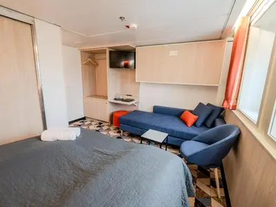 a bedroom with a blue bed and a couch at DFDS Ferry - Amsterdam to Newcastle in IJmuiden