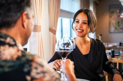 a woman holding a glass of wine with a man at DFDS Ferry - Amsterdam to Newcastle in IJmuiden