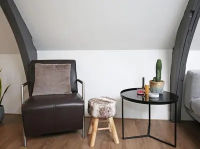 a living room with a chair and a table at Appartementen Purmerend B in Purmerend