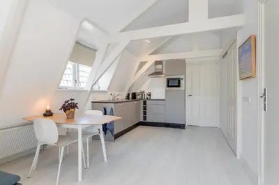 a kitchen and dining room with a table and chairs at Charming Apartments in Alkmaar