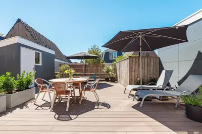 a patio with a table and chairs and an umbrella at Charming Apartments in Alkmaar