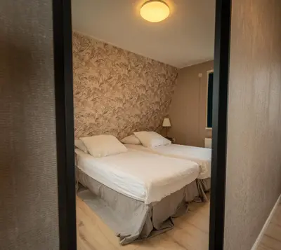 a bedroom with a bed with a wall at Hof van Schoorl in Schoorldam