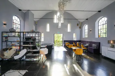a large room with tables and chairs and a chandelier at Valerius Boutique Hotel in Wormer