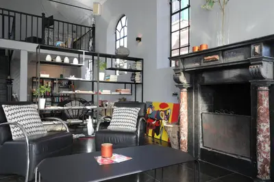 a living room with a fireplace and chairs at Valerius Boutique Hotel in Wormer