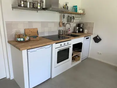 a kitchen with white appliances and a counter top at De Duinlopers- appt Zilt Zand- Strand, duinen en nabij cultuur steden in Castricum
