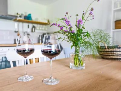 two glasses of red wine sitting on a table at De Duinlopers- appt Zilt Zand- Strand, duinen en nabij cultuur steden in Castricum