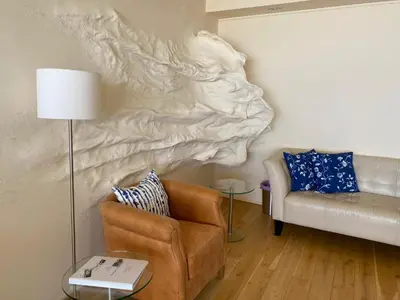 a living room with a couch and a chair at The wave in Zandvoort