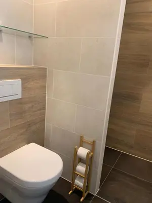 a bathroom with a toilet and a towel rack at The wave in Zandvoort