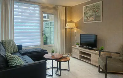 a living room with a couch and a television at Pet Friendly Home In Egmond Aan Zee in Egmond aan Zee
