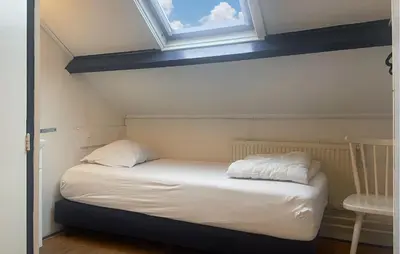 a small bed in a room with a window at Pet Friendly Home In Egmond Aan Zee in Egmond aan Zee